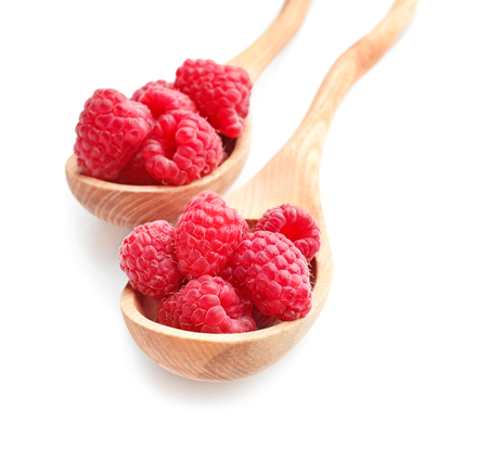 Wooden spoons with sweet ripe raspberries on white backgroundの写真素材