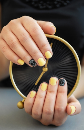 Female hands with stylish manicure holding alarm clock, closeupの写真素材