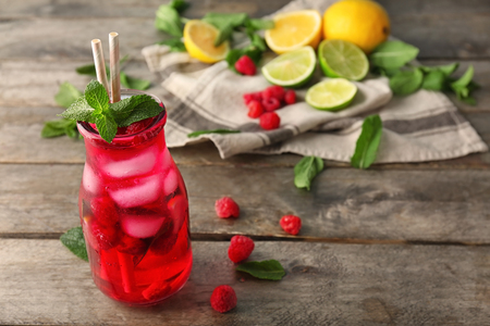 Bottle of fresh raspberry mojito on wooden tableの写真素材
