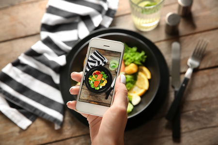Woman taking photo of diet food with mobile phoneの写真素材