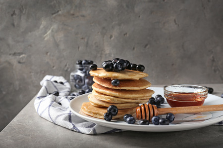 Plate with delicious pancakes and berries on light tableの写真素材