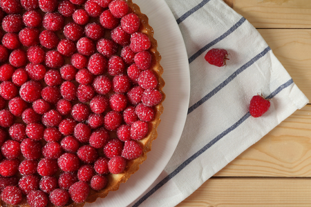 Tasty pie with fresh raspberries on wooden tableの写真素材