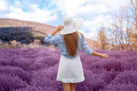 Beautiful young woman in lavender field on summer dayの写真素材