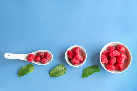 Composition with sweet ripe raspberries on color background
