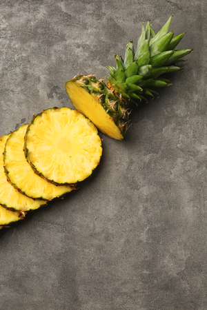Slices of ripe pineapple on grey backgroundの写真素材