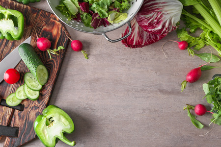 Cutting board with ingredients for vegetable salad on grey backgroundの写真素材
