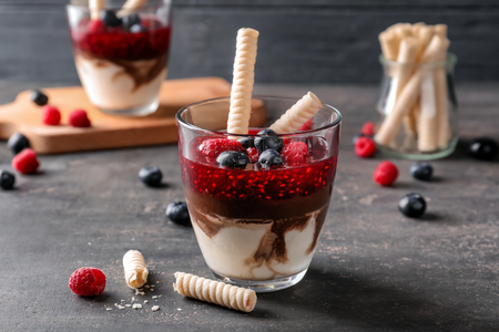Delicious dessert with berries in glass on tableの写真素材