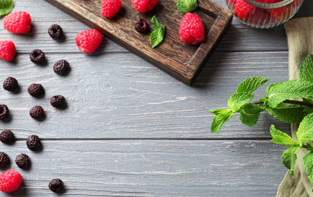 Delicious fresh ripe raspberries and blackberries on wooden background