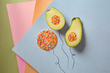 Composition with halves of ripe avocado and sprinkles on color background
