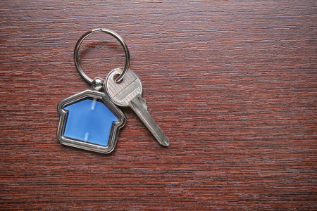 Key with trinket on wooden table. Mortgage conceptの写真素材