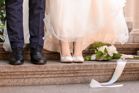 Happy wedding couple on stairs outdoorsの写真素材