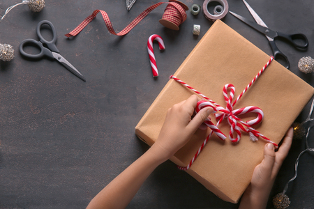 Child wrapping Christmas gift at table, top viewの写真素材