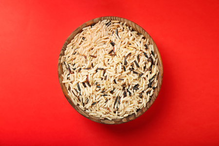 Bowl with raw rice on color backgroundの写真素材