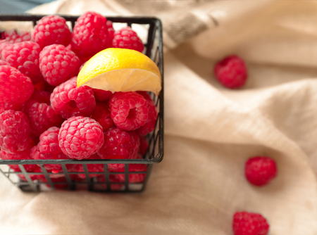 Basket with fresh ripe raspberries on table