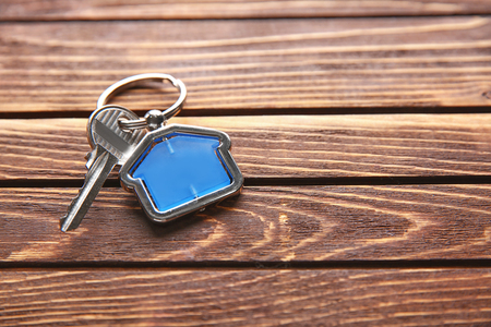 Key with trinket on wooden table. Mortgage conceptの写真素材