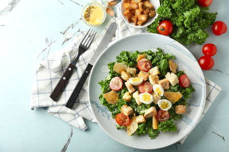 Plate with tasty Caesar salad on tableの写真素材