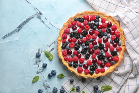 Delicious pie with ripe berries on table, top view
