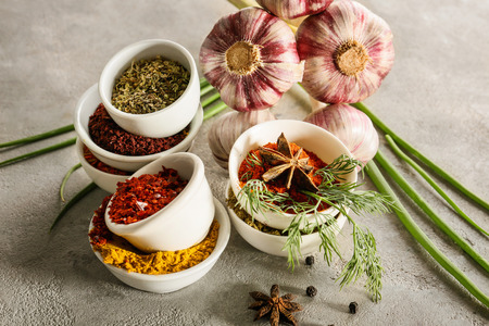 Bowls with different spices and garlic on grey textured backgroundの写真素材