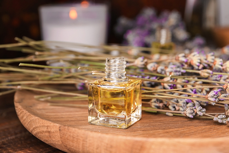 Bottle of essential oil with lavender on wooden boardの写真素材