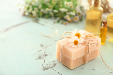 Bars of natural soap with chamomile flowers on tableの写真素材