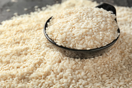 Bowl with raw rice on tableの写真素材