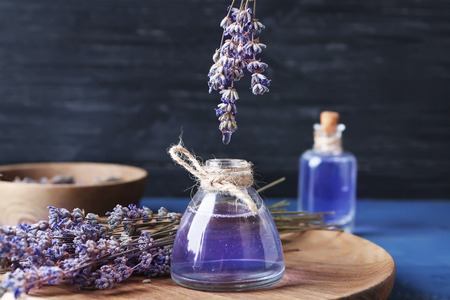 Dripping of lavender essential oil into bottle on wooden boardの写真素材