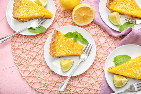 Plates with pieces of tasty lemon pie on tableの写真素材