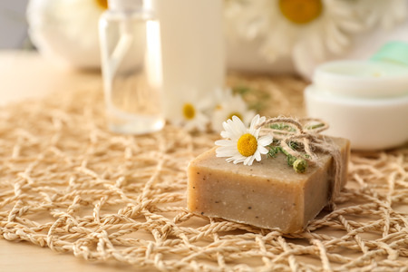 Bar of natural soap with chamomile flower on tableの写真素材