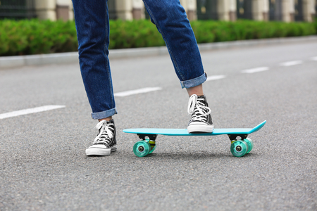 Hipster girl riding skateboard outdoorsの写真素材