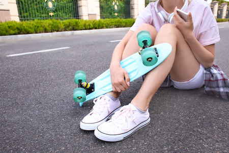 Hipster girl with skateboard outdoorsの写真素材