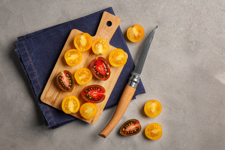 Wooden board with fresh ripe cherry tomatoes on tableの写真素材
