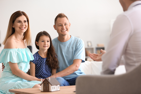 Happy family with real estate agent in officeの写真素材