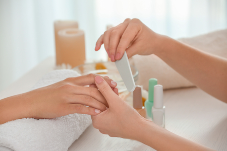 Young woman getting professional manicure in beauty salon, closeupの写真素材