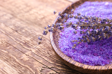 Beautiful lavender and bowl with sea salt on wooden table, closeupの写真素材
