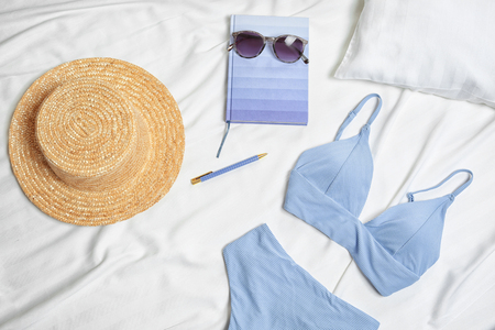 Composition with swimming suit and accessories on bed linenの写真素材