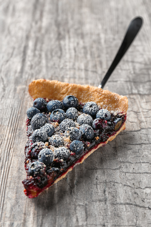 Shovel with piece of delicious blueberry pie on wooden tableの写真素材