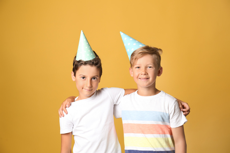 Cute little boys in Birthday hats on color backgroundの写真素材
