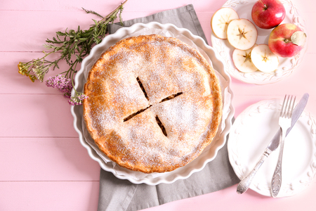 Plate with delicious apple pie and flowers on wooden tableの写真素材