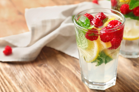 Glass of fresh raspberry mojito on wooden tableの写真素材