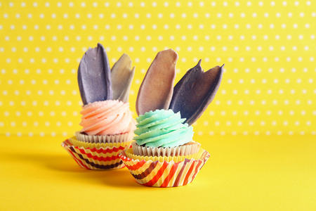 Delicious birthday cupcakes on color background
