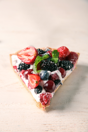 Piece of delicious berry pie on white wooden tableの写真素材