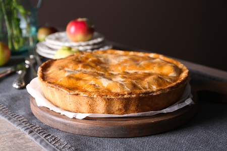 Board with delicious apple pie on tableの写真素材