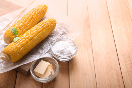 Composition with boiled corncobs on wooden tableの写真素材