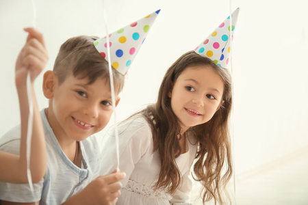 Cute little children in Birthday hats indoorsの写真素材