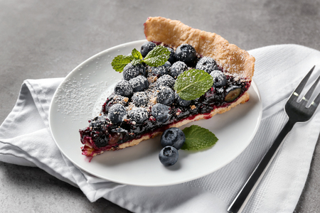 Plate with piece of delicious blueberry pie on tableの写真素材