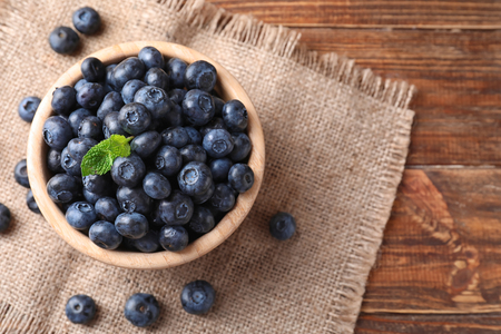 Bowl with ripe blueberries on wooden tableの写真素材