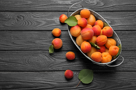 Basket with ripe sweet apricots on wooden backgroundの写真素材