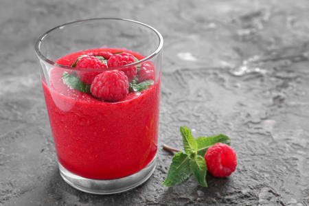 Glass of tasty raspberry smoothie on tableの写真素材