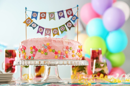 Stand with beautiful tasty birthday cake on tableの写真素材