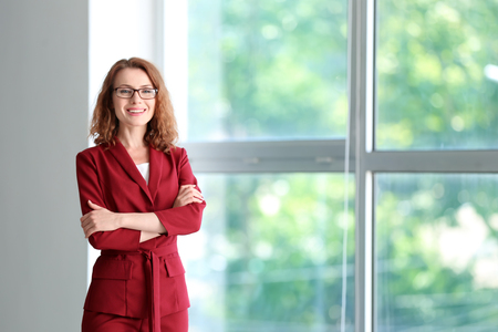 Successful businesswoman near window in officeの写真素材